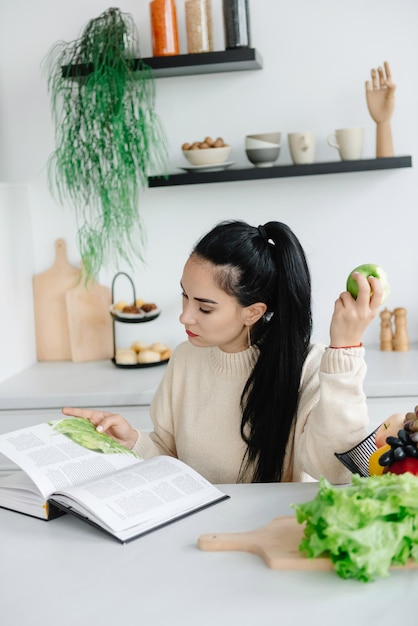 ダイエット中の若い女性は菜食主義者であり、健康的な食事と生活についての雑誌を読んでいます