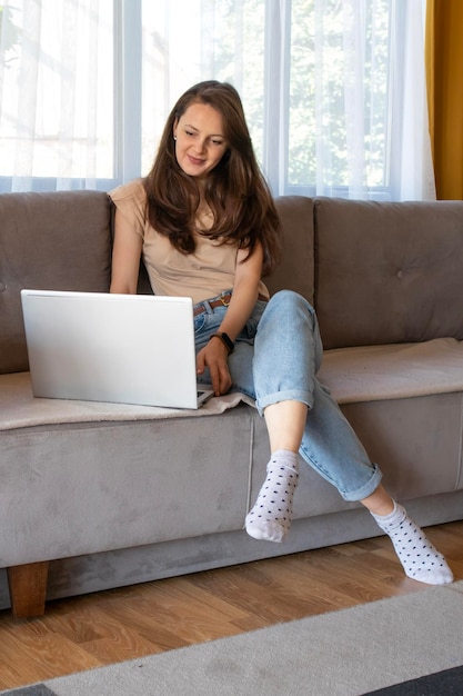 A young woman is doing online shopping remotely Comfortable home in a cozy and stylish apartment