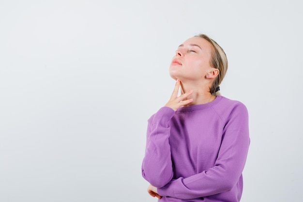 The young woman is dreaming by holding her hand under chin on white background