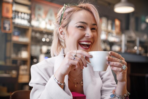 Photo young woman is drinking coffee in a cafe