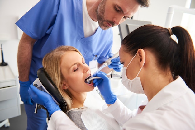 young woman is getting treatment in dentist's office