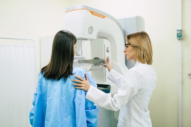 Молодая женщина проходит маммографическое обследование в больнице или частной клинике у профессионального врача-женщины.