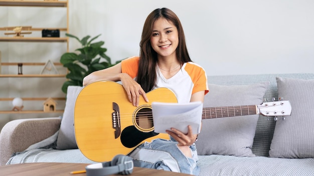 Young woman is holding a book of lyrics and chords to playing gu