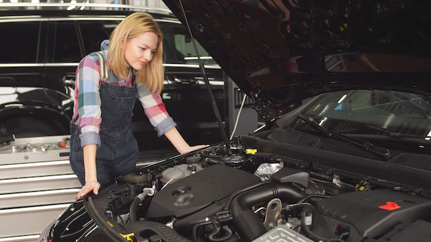 Young woman is interested in car repair, a favorite hobby