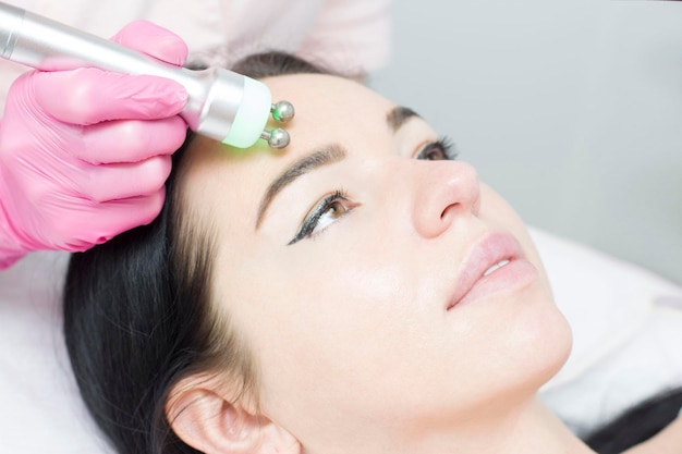 A young woman is lying on the rflifting procedure for face skin
tightening and face contour correction closeup