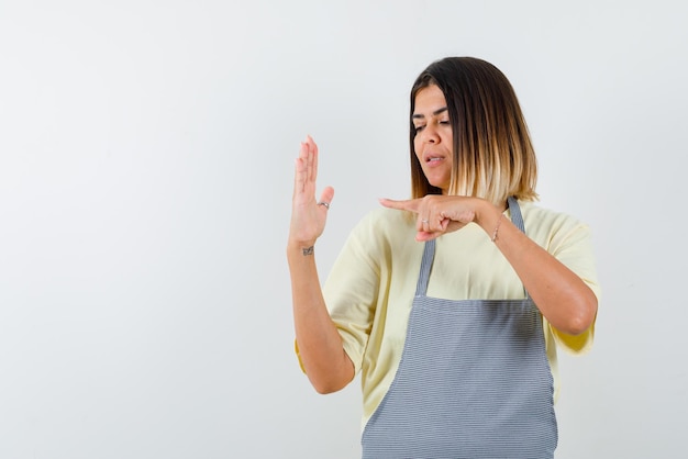 The young woman is pointing her hand with forefinger on white background