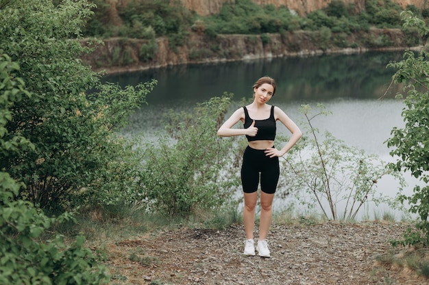 Young woman is practicing yoga at mountain lake