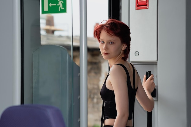 Young woman is preparing to get off at a station from a commuter train car