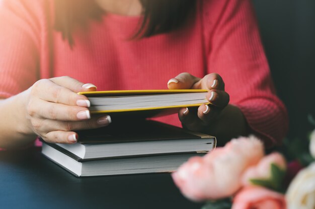 Young woman is reading a book at home. Blurred background. Horizontal, film effect.