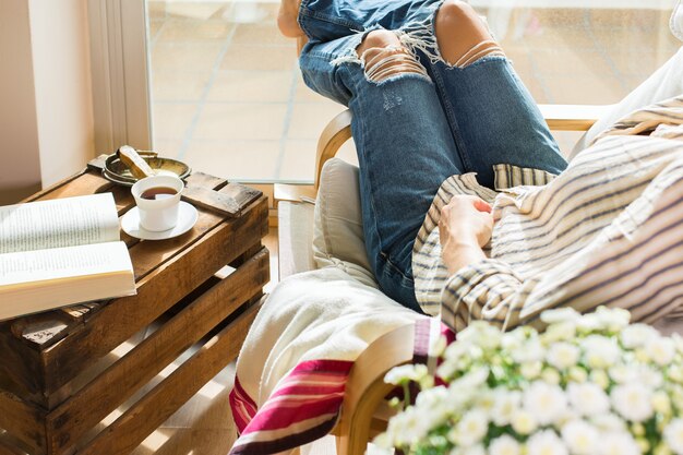 Young woman is relaxing at home drinking tea reading book