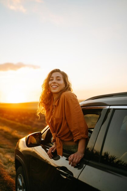 Foto giovane donna si riposa e si gode il tramonto in macchina stile di vita viaggi turismo natura vita attiva