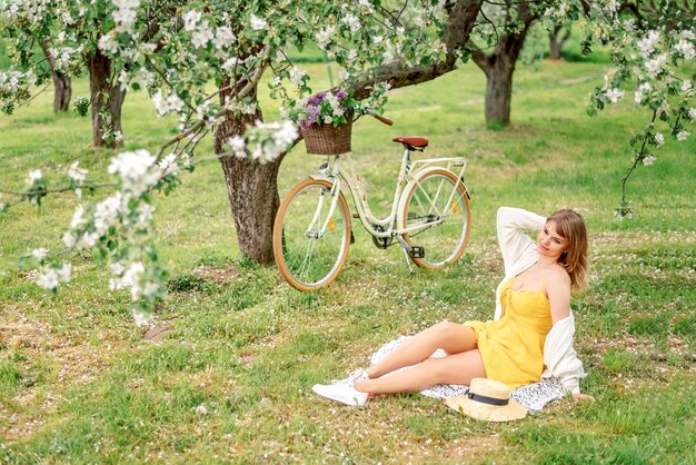 young woman is resting in a spring blooming garden