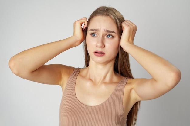 Young woman is in shock or surprise of the news against gray background