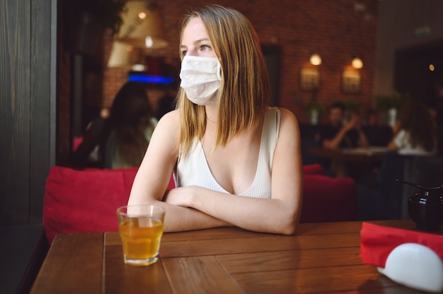 Young woman is sitting in a cafe and waiting for her order