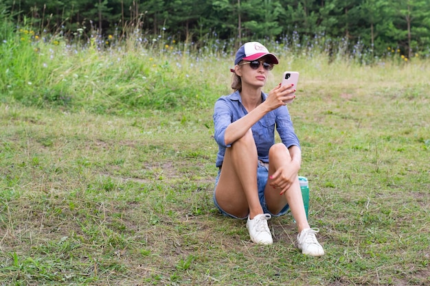 Young woman is sitting on grass