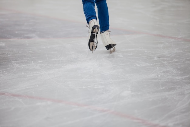 Young woman is skating on the rink. Close up view on the back of skates