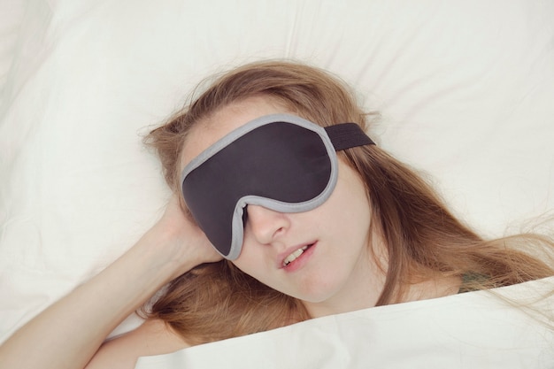 Young woman is sleeping in a mask for sleep. Relaxation