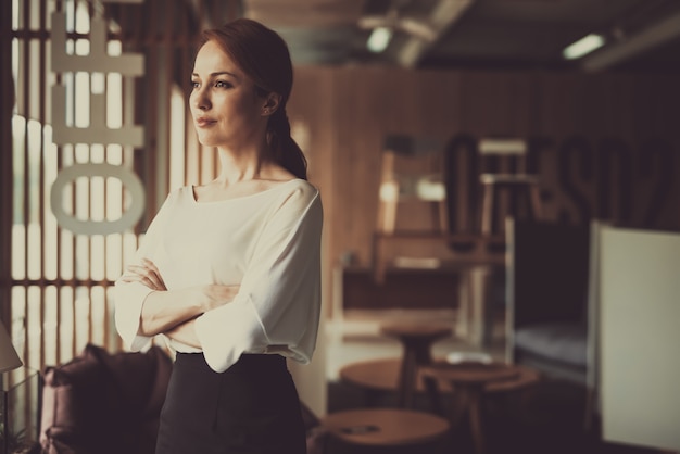 Young Woman Is Standing In Office Arms Akimbo