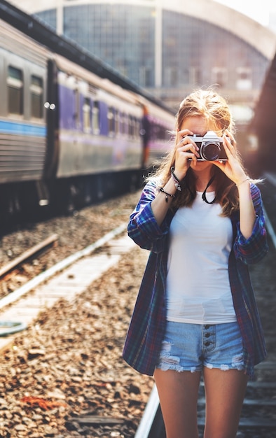 Young woman is taking photo with film camera