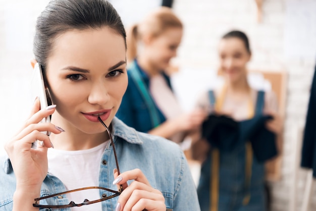 Young woman is talking on phone at work.