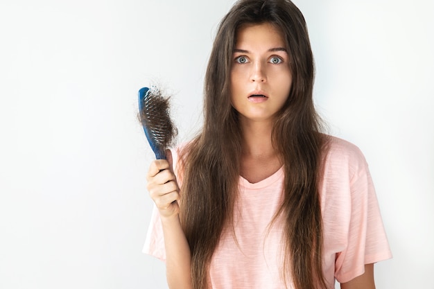 Young woman is upset because of hair loss