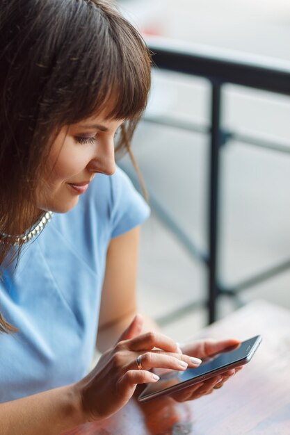 若い女性が彼女のスマートフォンを使っています