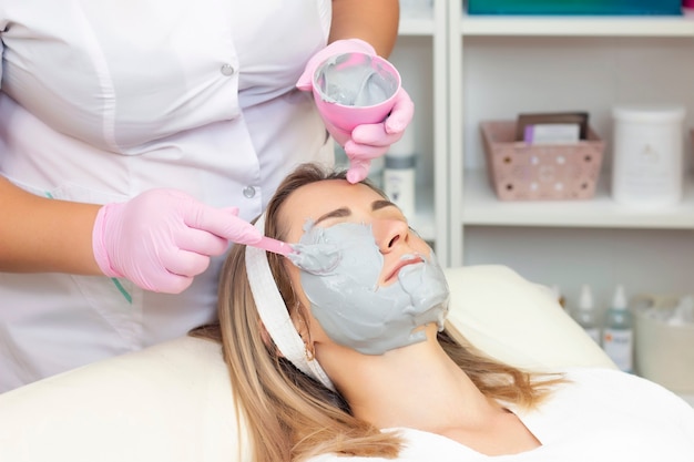 Young woman is wearing a gray alginate mask