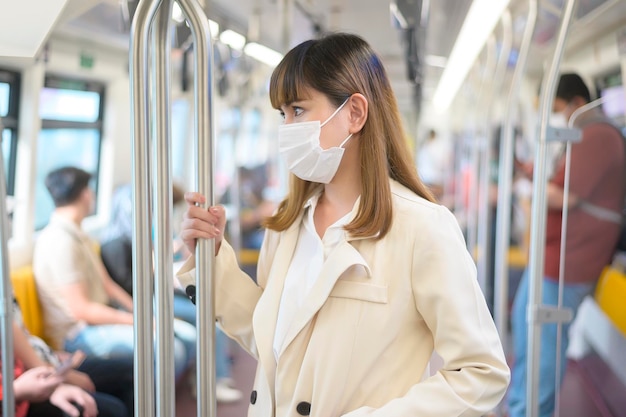 A young woman is wearing protective mask in metro  travel under pandemic concept