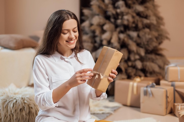 Young woman is wrapping christmas presents for holidays