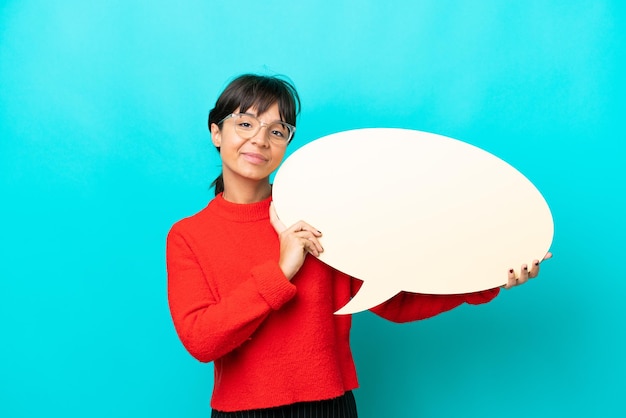 Young woman isolated on blue background holding an empty speech bubble