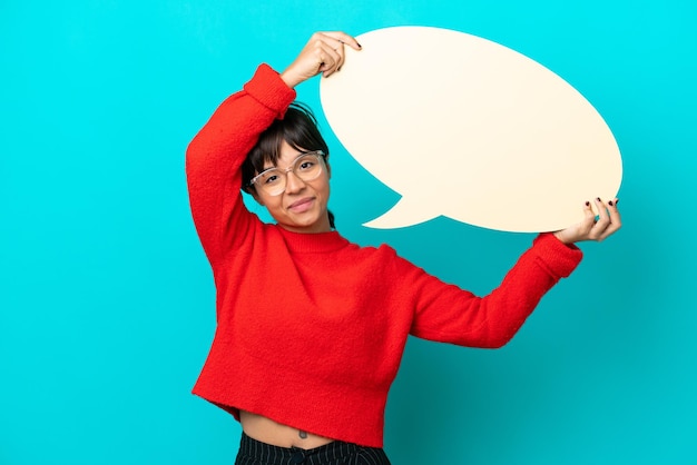 Young woman isolated on blue background holding an empty speech bubble