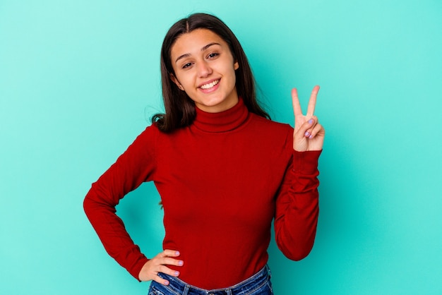 Young woman isolated on blue wall showing number two with fingers