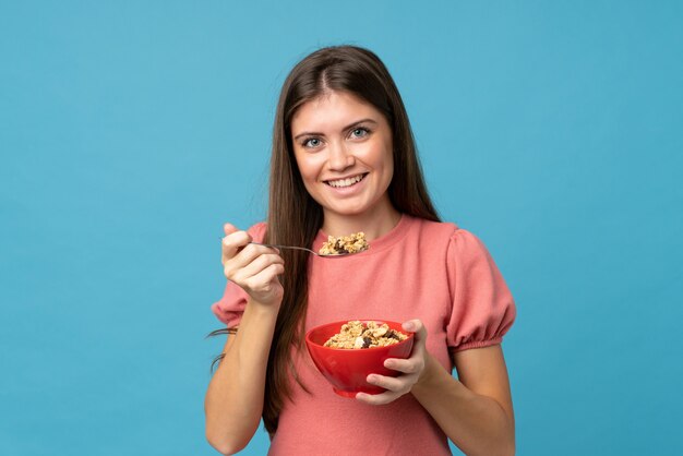 Young woman over isolated  holding a bowl of cereals