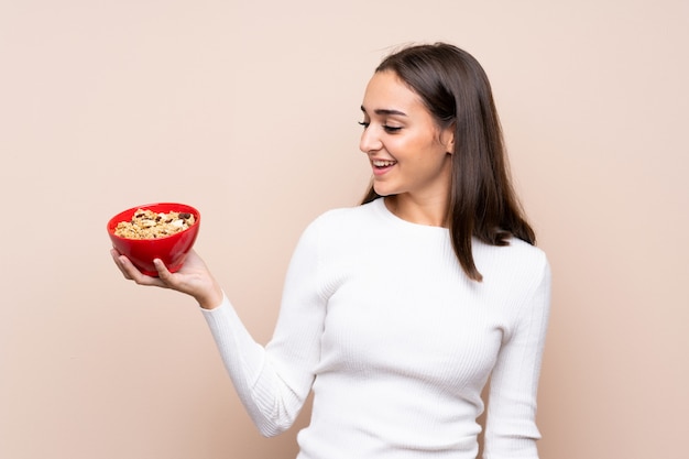 Giovane donna isolata sopra tenendo una ciotola di cereali