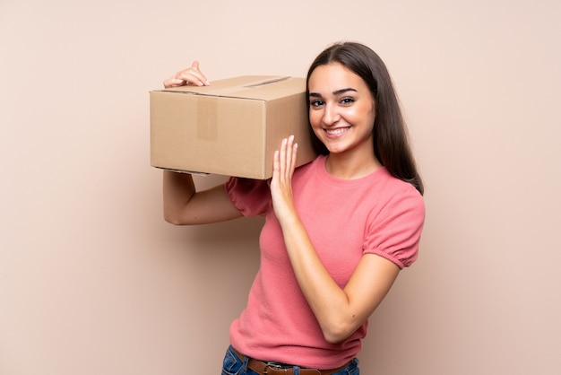 Young woman over isolated holding a box to move it to another site