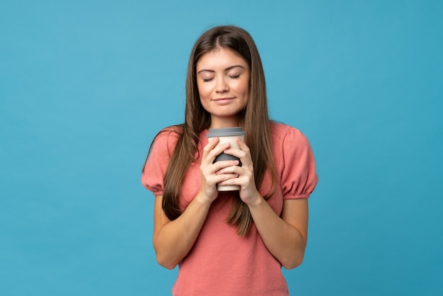 Young woman over isolated  holding coffee to take away