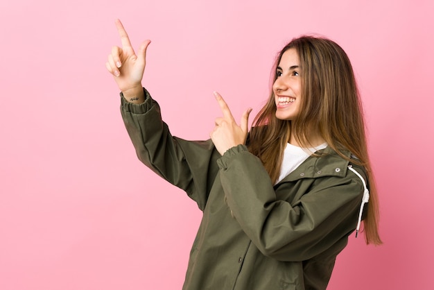 Young woman over isolated pink wall pointing with the index finger a great idea