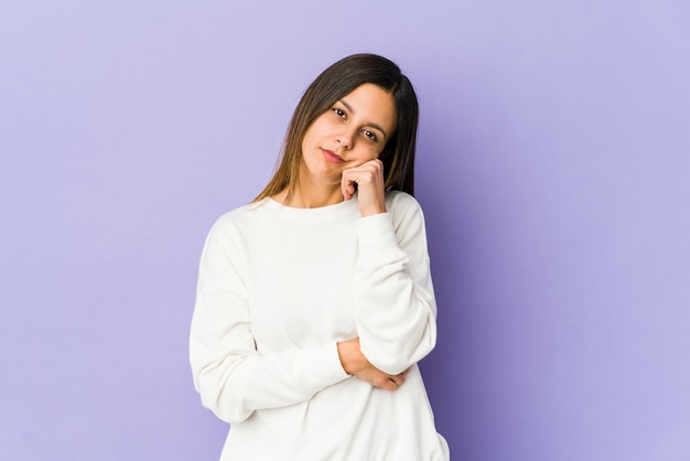 Young woman isolated on purple space tired of a repetitive task.