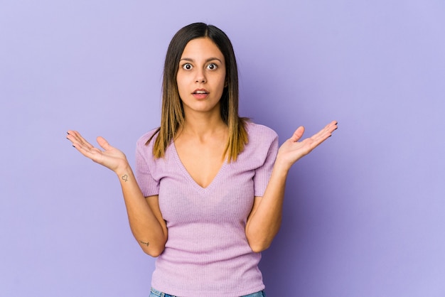 Young woman isolated on purple surprised and shocked.