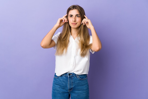 Young woman over isolated purple wall having doubts and thinking