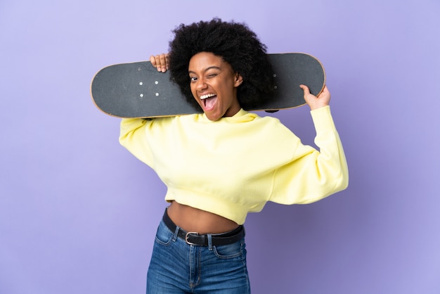 Young woman isolated on purple with a skate