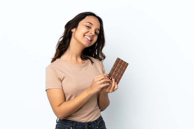 Young woman isolated taking a chocolate tablet