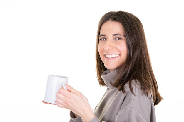 Young woman over isolated white background holding hot cup of coffee in blank mug