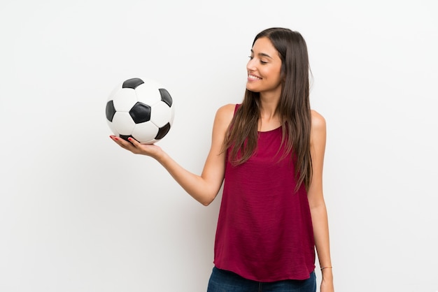 Молодая женщина над изолированной белизной держа футбольный мяч