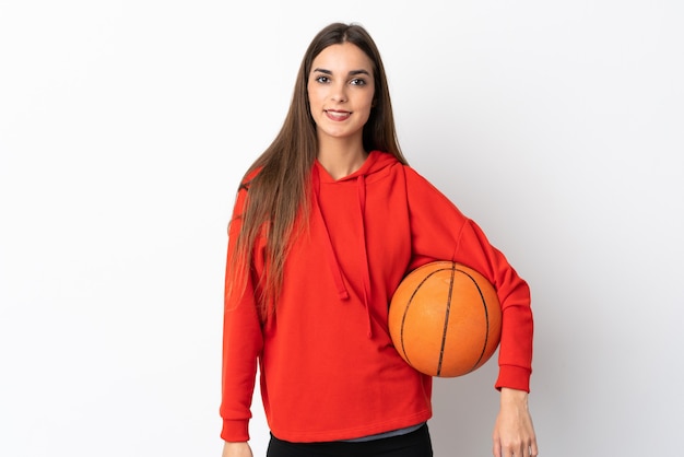 Young woman isolated on white wall playing basketball