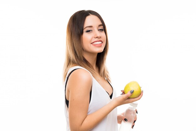 Young woman over isolated white wall with an apple