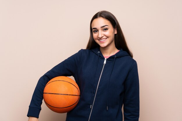 Young woman over isolated  with ball of basketball