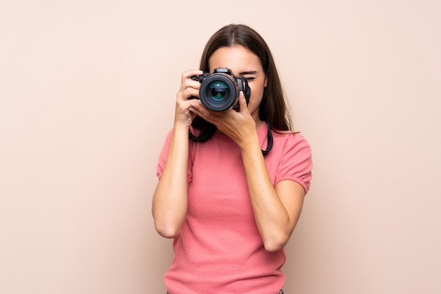 Foto giovane donna isolata con una macchina fotografica professionale