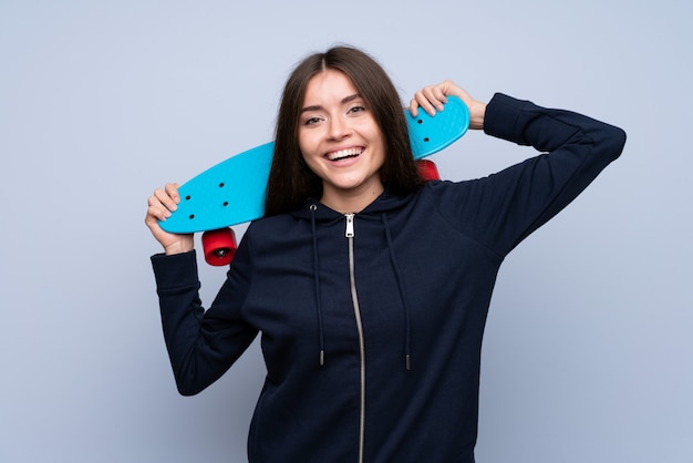 Young woman over isolated  with skate