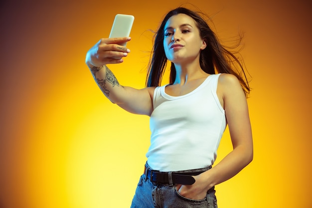 Young woman isolated on yellow wall. Stylish, trendy look